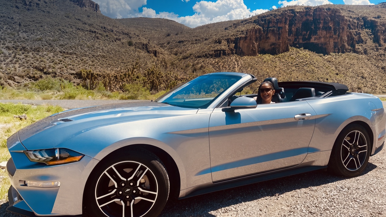 Convertible plateado en una carretera entre montañas