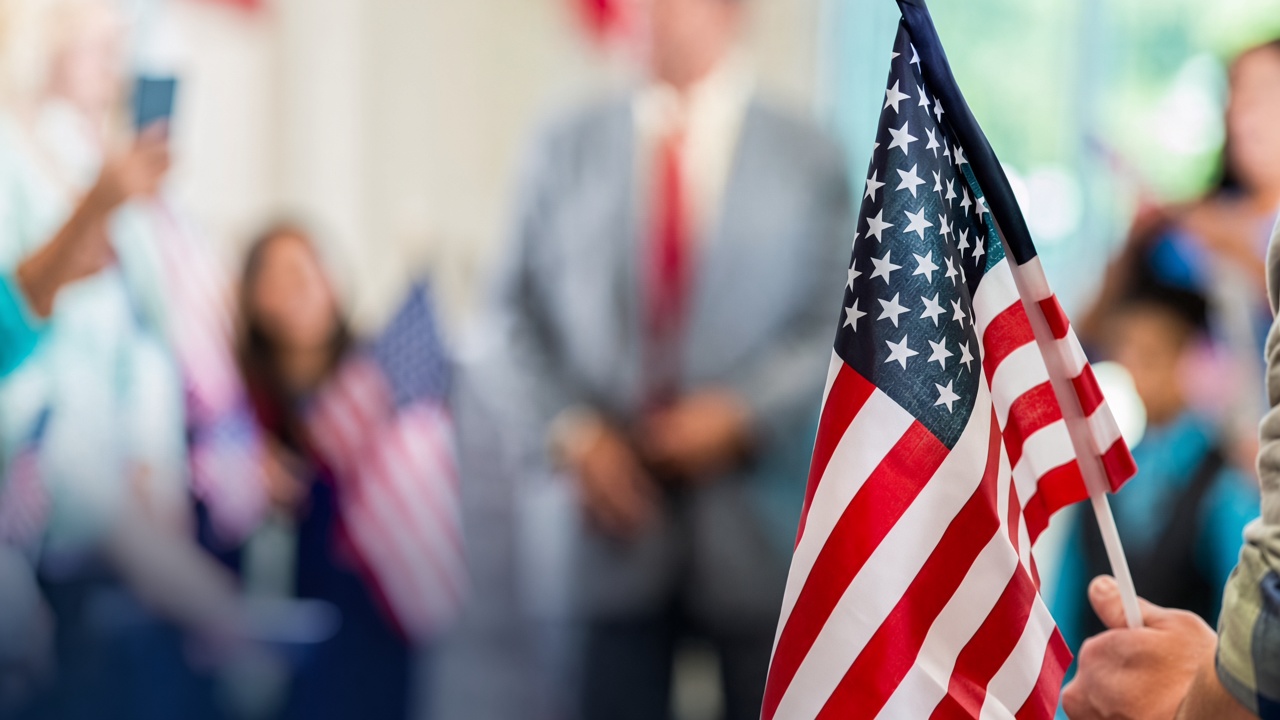 Bandera de Estados Unidos en primer plano, con personas al fondo